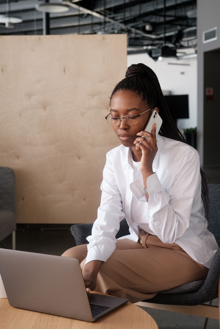 Woman on a phone call working on a laptop